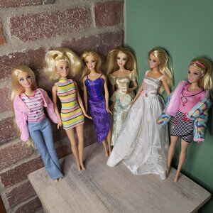 6 Barbie dolls wearing different outfits